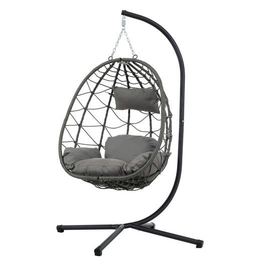Cozy hanging egg chair with dark grey rattan and metal frame, including cushions and stand.