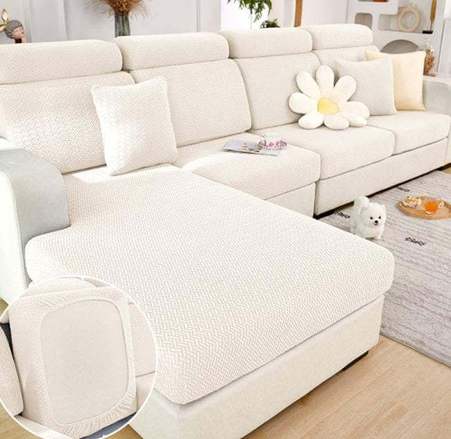 Modern all-season elastic sofa slipcover in white knitted fabric covering sectional sofa with pillows and dog in living room