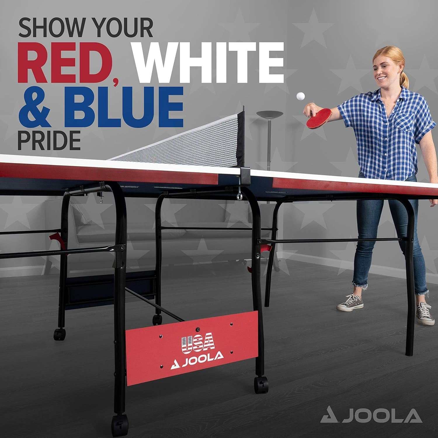 Woman playing on foldable indoor ping pong table with patriotic red, white, and blue design and JOOLA branding.