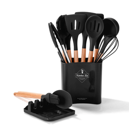 Silicone kitchen tools set with wooden handles in a black holder, including spatulas, tongs, and whisk for cooking.