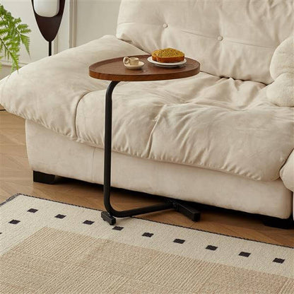 C shaped side table used as bedside table in bedroom setting