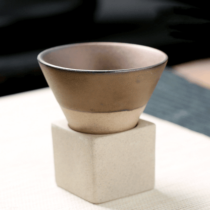 Japanese retro ceramic coffee cup on a light background, featuring a unique conical design and beige base.
