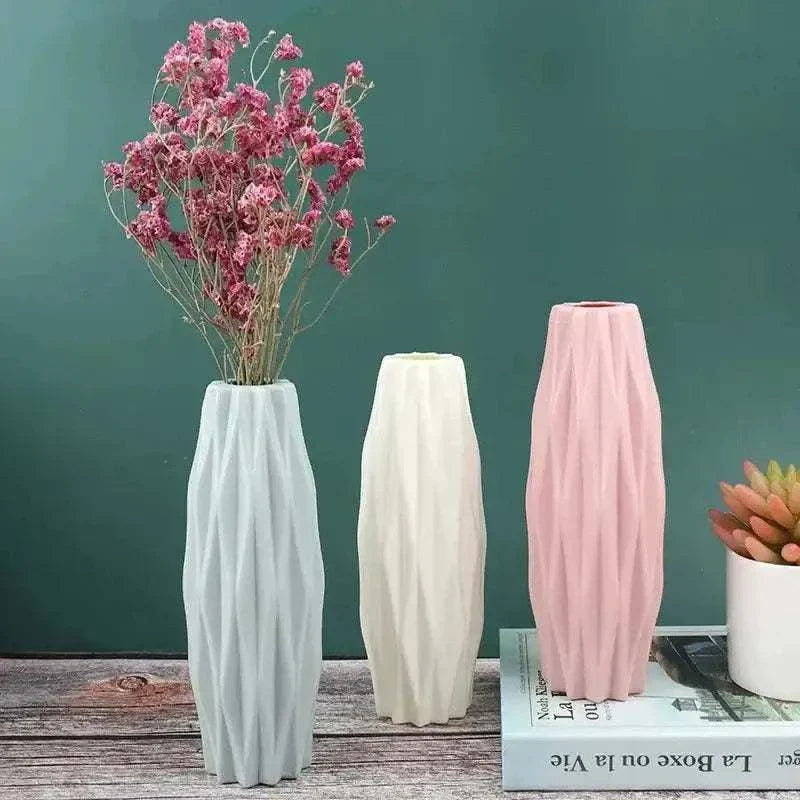 Three Diamond Pattern Faux Ceramic Vases in pastel blue, white, and pink with textured design on wooden surface and flowers in one vase