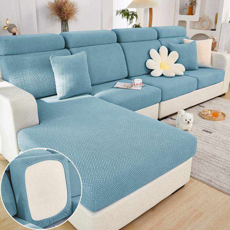 Blue elastic sofa slipcover protecting sectional sofa with textured knit fabric in modern living room