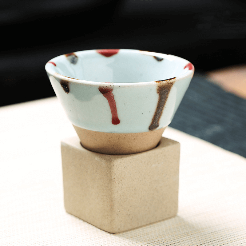 Japanese retro ceramic coffee cup with colorful drip design on a beige stand, 100ml capacity.