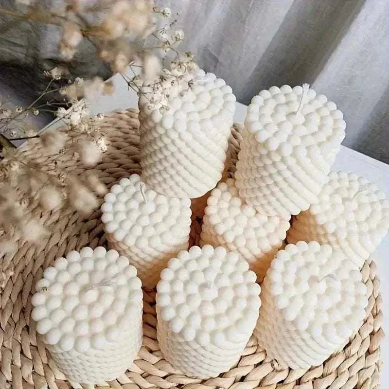 Set of round 3D bubble candles in creamy white, arranged on a woven tray with dried flowers.