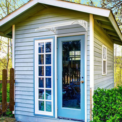 Transparent RainGuard Awning protecting a blue door and window on a small house exterior