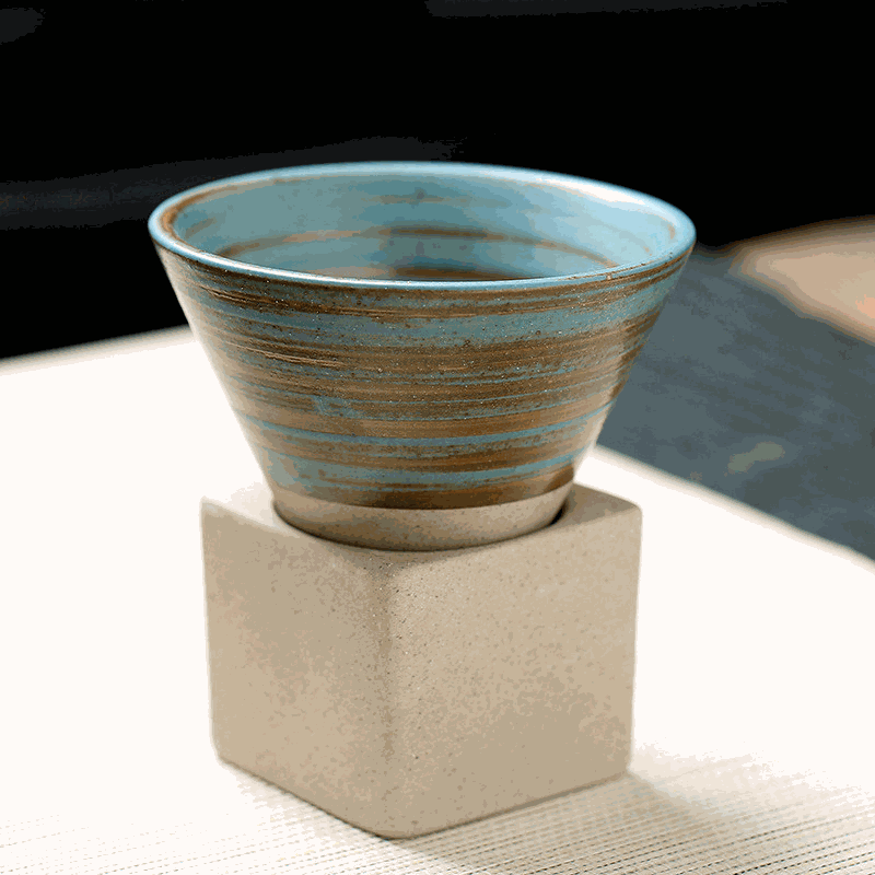Japanese retro ceramic coffee cup with blue glaze on a light stone stand, ideal for coffee lovers.
