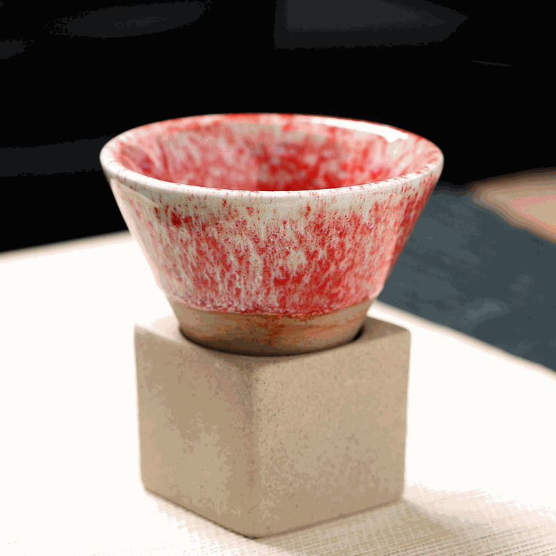 Japanese Retro Ceramic Coffee Cup with red speckled design, displayed on a square beige base.