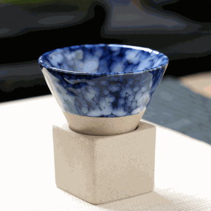 Japanese retro ceramic coffee cup with blue glaze resting on a square base, showcasing unique craftsmanship.