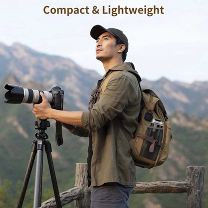 Man carrying backpack with portable coffee brewer in side pocket while setting up camera tripod outdoors in mountainous area