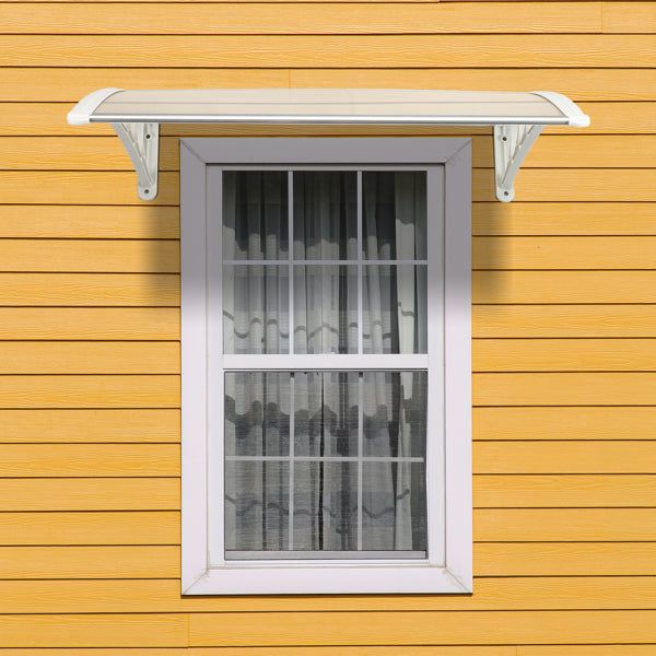 Transparent RainGuard Awning installed above window with yellow siding background