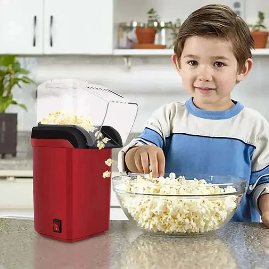 Child enjoying freshly popped popcorn from a hot air popcorn maker in a kitchen.