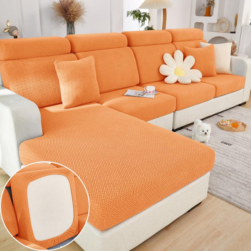 Orange elastic sofa slipcover on modern sectional sofa with textured knit fabric and flower cushion