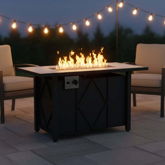 A propane fire pit table with flames, perfect for outdoor gatherings, surrounded by chairs and string lights.