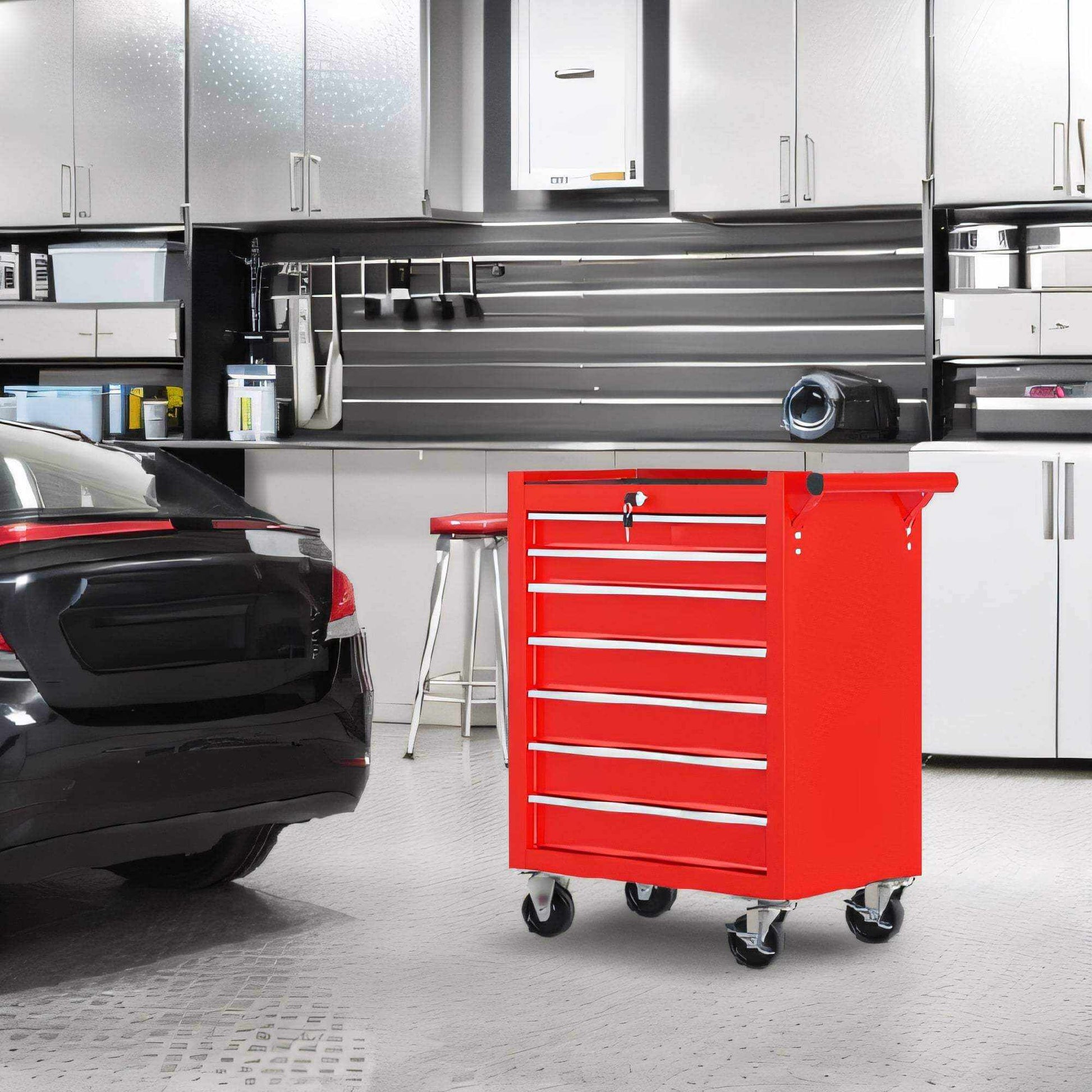 Red 7-drawer Ultimate Rolling Tool chest with heavy-duty wheels in modern garage workspace next to black car and storage cabinets