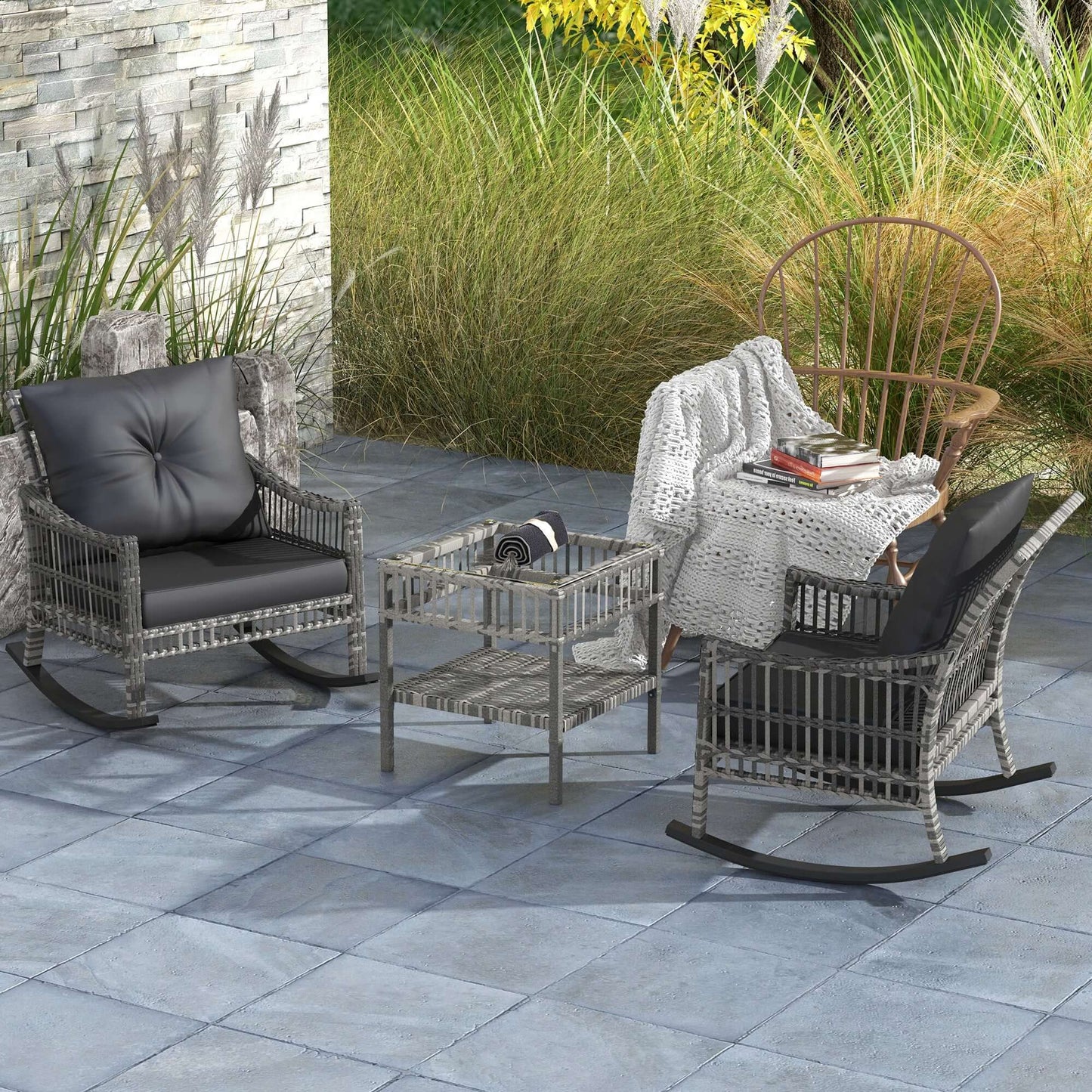 Outdoor rattan rocking chair set with gray cushions and glass table