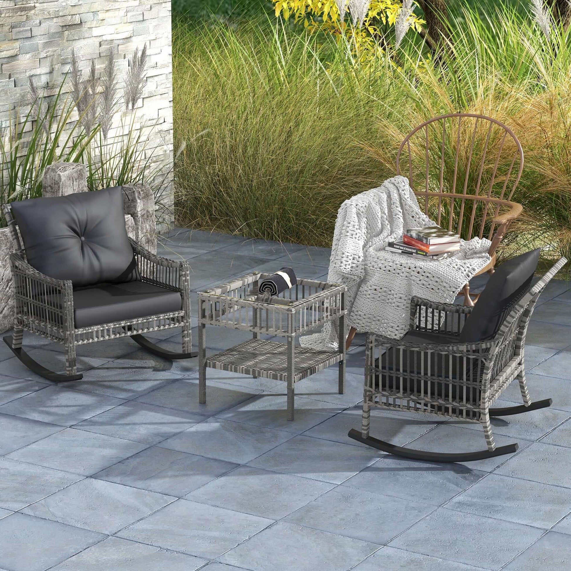 Outdoor rattan rocking chair set with gray cushions and glass table