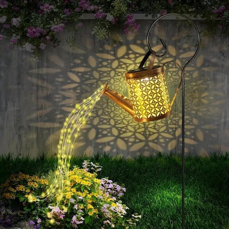 solar watering can string lights hanging on fence