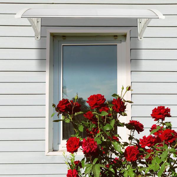 Weatherproof clear RainGuard Awning door canopy with aluminum brackets over window and red roses beneath