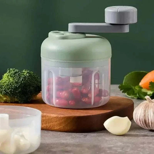 Compact hand-crank food chopper with ingredients, perfect for mincing vegetables quickly and efficiently.