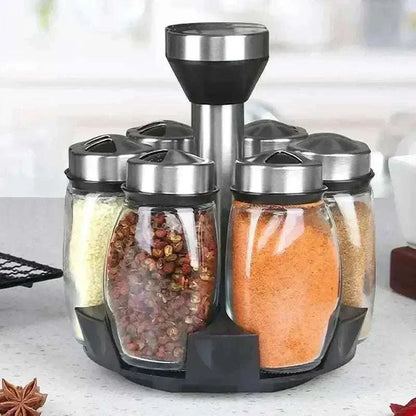 Glass spice rack organizer set with rotating base and transparent bottles for easy seasoning access.