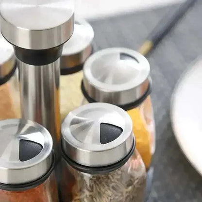 Close-up of glass spice jars with stainless steel lids on a rotating organizer, showcasing easy access and storage.